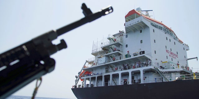 Sailors stand on deck above a hole the U.S. Navy says was made by a limpet mine on the damaged Panama-flagged, Japanese owned oil tanker Kokuka Courageous, anchored off Fujairah, United Arab Emirates, during a trip organized by the Navy for journalists, Wednesday, June 19, 2019.