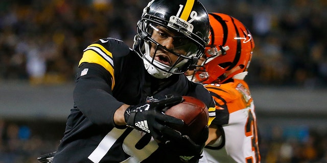 JuJu Smith-Schuster #19 of the Pittsburgh Steelers reaches into the end zone for an 11-yard touchdown reception as Jessie Bates #30 of the Cincinnati Bengals defends in the third quarter during the game at Heinz Field on December 30, 2018 in Pittsburgh, Pennsylvania. (Photo by Justin K. Aller/Getty Images)