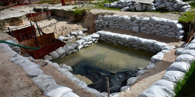 This June 1, 2019 photo provided by History Flight shows graves of U.S. servicemen under the water table in Tarawa, Kiribati. (Eric Albertson/Defense POW/MIA Accounting Agency/History Flight via AP)