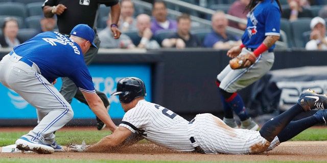 Toronto Blue Jays starting pitcher Clayton Richard, left, tags out New York Yankees' Giancarlo Stanton at third during the first inning of a baseball game Tuesday, June 25, 2019, in New York. Stanton left the game after the third inning. (AP Photo/Kathy Willens)