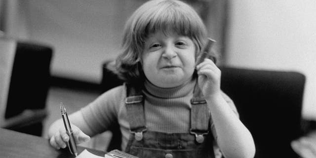 Child model Mason Reese seated at a table.