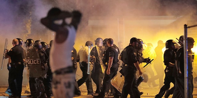 Police retreat under a cloud of tear gas as protesters disperse from the scene of a standoff after Frayser community residents took to the streets in anger against the shooting of a youth by U.S. Marshals earlier in the evening, Wednesday, June 12, 2019, in Memphis, Tenn. (Associated Press)