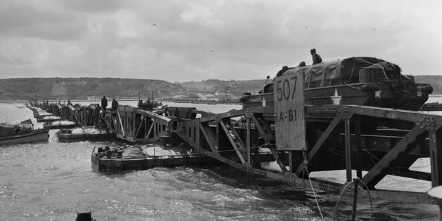 File photo - 'Mulberry', the secret floating harbor being put to good use on Omaha beach in Normandy as a large truck drives over one of the pontoons. Mulberry was later destroyed by channel storms.