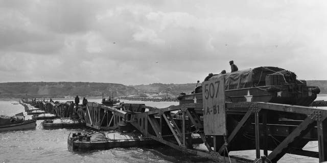 File photo - 'Mulberry', the secret floating harbor being put to good use on Omaha beach in Normandy as a large truck drives over one of the pontoons. Mulberry was later destroyed by channel storms.