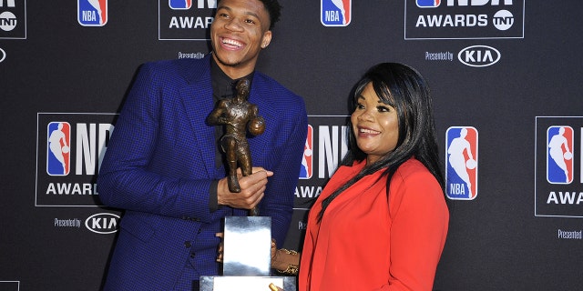 NBA player Giannis Antetokounmpo, of the Milwaukee Bucks, winner of the most valuable player award, left, and mother Veronica Antetokounmpo pose in the press room at the NBA Awards on Monday, June 24, 2019, at the Barker Hangar in Santa Monica, Calif. (Photo by Richard Shotwell/Invision/AP)