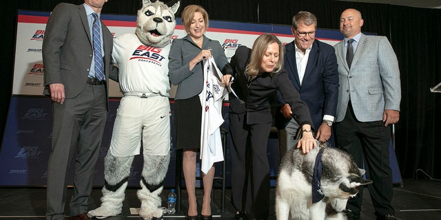 University of Connecticut men's basketball coach Dan Hurley, left, University President Susan Herbst, third left, Big East Commissioner Val Ackerman, fourth left, women's basketball coach Geno Auriemma, fifth left, and Director of Athletics David Benedict, pose for photos during the announcement that the University of Connecticut is re-joining the Big East Conference, at New York's Madison Square Garden, Thursday, June 27, 2019. (AP Photo/Richard Drew)