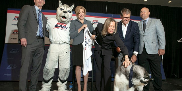 University of Connecticut men's basketball coach Dan Hurley, left, University President Susan Herbst, third left, Big East Commissioner Val Ackerman, fourth left, women's basketball coach Geno Auriemma, fifth left, and Director of Athletics David Benedict, pose for photos during the announcement that the University of Connecticut is re-joining the Big East Conference, at New York's Madison Square Garden, Thursday, June 27, 2019. (AP Photo/Richard Drew)