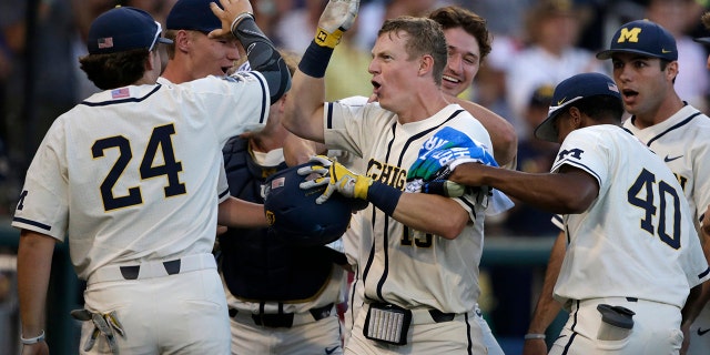 Michigan's Jimmy Kerr, center, is congratulated after hitting a 2-run home run against Vanderbilt during the seventh inning in Game 1 of the NCAA College World Series baseball finals in Omaha, Neb., Monday, June 24, 2019. (AP Photo/Nati Harnik)