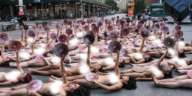People pose nude for a photo shoot by artist Spencer Tunick in front of Facebook's New York headquarters in Manhattan Sunday. (Photo by Stephanie Keith/Getty Images)