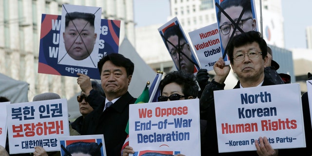In this Feb. 26, 2019, file photo, South Korean protesters and North Korean defectors hold portraits of North Korean leader Kim Jong Un.