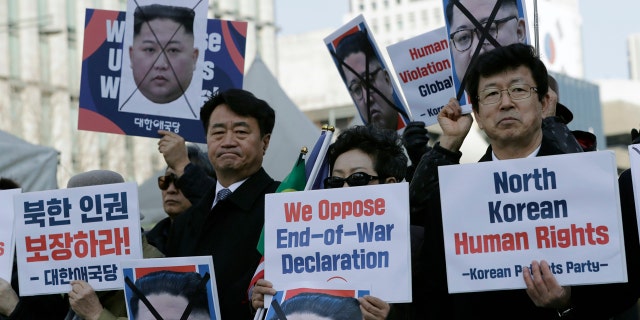 In this Feb. 26, 2019, file photo, South Korean protesters and North Korean defectors hold portraits of North Korean leader Kim Jong Un.