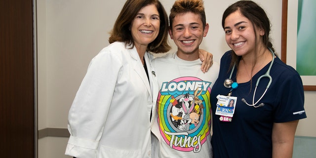 Michael Pruitt is pictured with Dr. Angel Chudler and nurse Yasmeen Bachir, who helped bring him back to life after he had no vital signs for 20 minutes.