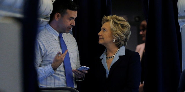 Hillary Clinton and national press secretary Brian Fallon talking onboard her campaign plane in White Plains, New York, in October 2016.