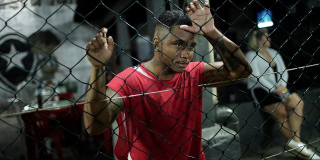In this May 27, 2019 photo, Bruno dos Santos watches a soccer game between his Bigtboys transgender men's team and the Alligaytors, a gay men's team in Rio de Janeiro, Brazil. For the two dozen Bigtboys players, the pitch is also one of the few places where they feel at ease and can talk about their experiences, good and bad, without fear. (AP Photo/Silvia Izquierdo)