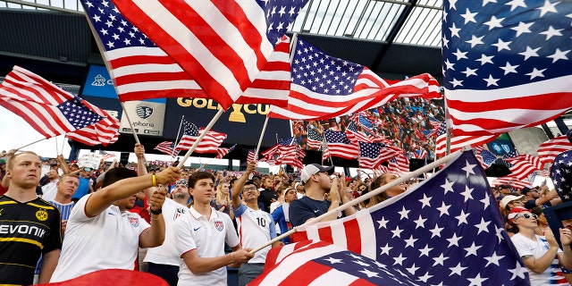 Fans of the U.S. team wave flags as the players are introduced for a CONCACAF Gold Cup soccer match against Panama in Kansas City, Kan., Wednesday, June 26, 2019. (AP Photo/Colin E. Braley)