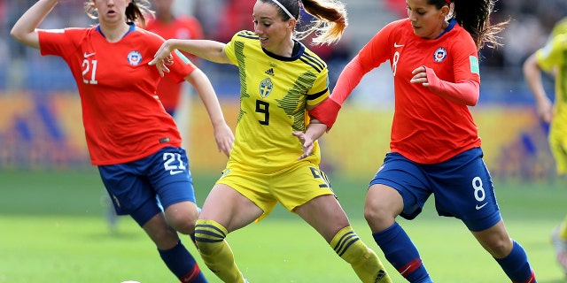 Sweden's Kosovare Asllani, center, and Chile's Karen Araya, right, challenge for the ball during the Women's World Cup Group F soccer match between Chile and Sweden at the Roazhon Park in Rennes, France, Tuesday, June 11, 2019. (AP Photo/David Vincent)