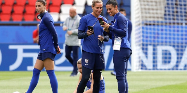 United States' Alex Morgan, left, walks past, her teammates Ashlyn Harris, center, and Ali Krieger during a visit at the Parc des Princes stadium a day before the Group F soccer match between United States and Chile. (AP Photo/Alessandra Tarantino)