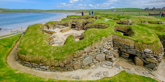 Tourists visiting Skara Brae, a Neolithic settlement located in the Mainland Orkney. In this prehistoric village, one of the best preserved groups of prehistoric houses in Western Europe, people can see the way of life of 5,000 years ago, before Stonehenge was built. (Credit: iStock)