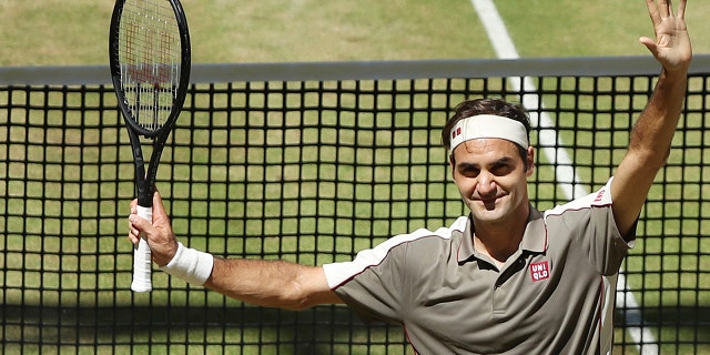 Swiss Roger Federer celebrates after winning the tennis ATP final against Belgium David Goffin in Halle, Germany, Sunday, June 23, 2019. (Friso Gentsch/dpa via AP)