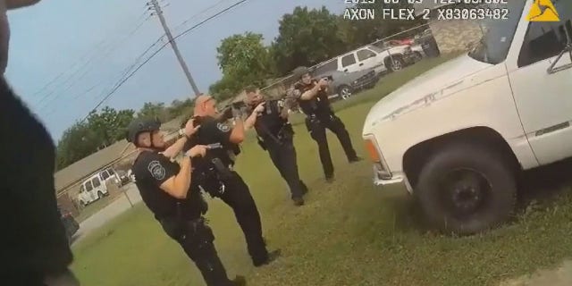 Officers can be seen forming a semi-circle around a truck where 20-year-old JaQuavion Slaton was hiding before opening fire when one officer shouted "he's reaching!"