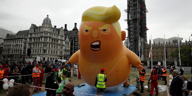 The 'Trump Baby' blimp is inflated in Parliament Square in central London as people start to gather to demonstrate against the state visit of President Donald Trump, Tuesday. (AP Photo/Matt Dunham)
