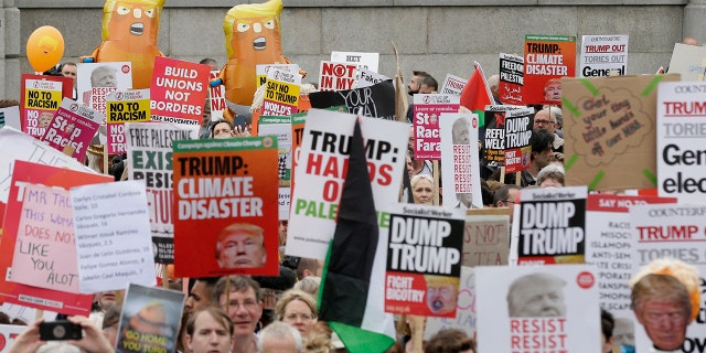 People carry signs and banners as they gather in Trafalgar Square, central London, to demonstrate against the state visit of President Donald Trump, Tuesday. (AP Photo/Tim Ireland)