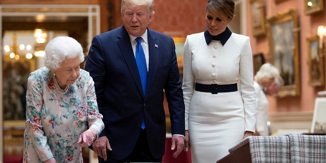 Queen Elizabeth II looking at a display of U.S. items of the Royal collection with President Trump and first lady Melania Trump at Buckingham Palace on Monday. (Ian Vogler/Pool via REUTERS)