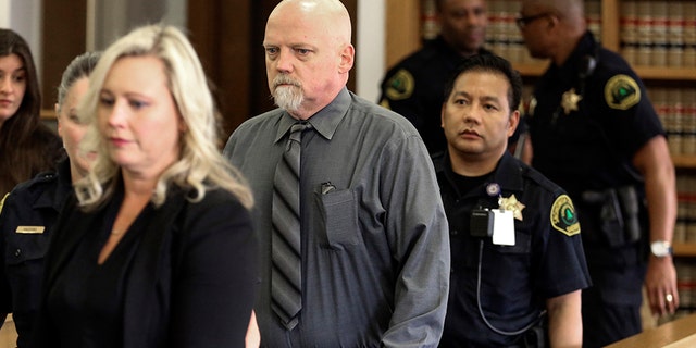 William Talbott II, center, is escorted to his seat Friday, June 28, 2019, at the Snohomish County Courthouse in Everett, Wash. William Earl Talbott II has been found guilty in the 1987 killings of a young Canadian couple, Tanya Van Cuylenborg and Jay Cook. (Kevin Clark/The Herald via AP, Pool)