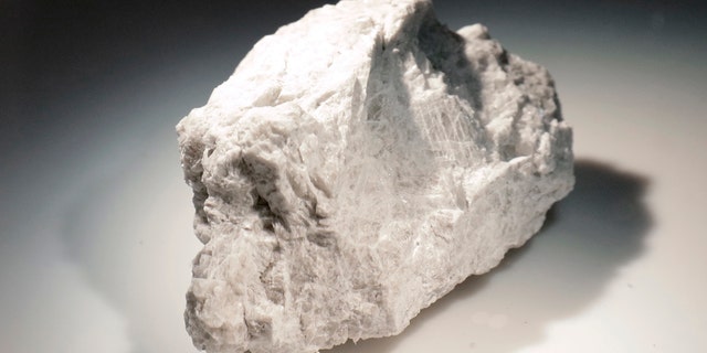 The "Genesis Rock," a 4.4 billion-year-old anorthosite sample approximately 2 inches in length, brought back by Apollo 15 and used to determine the moon was formed by a giant impact, is lit inside a pressurized nitrogen-filled examination case in the lunar lab at the NASA Johnson Space Center Monday, June 17, 2019, in Houston. (AP Photo/Michael Wyke)