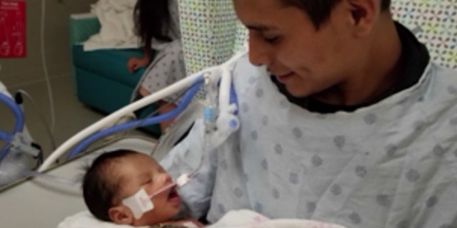 Yovani Lopez holds his son, Yovanny Jadiel Lopez, in the hospital in this photo released by family members.