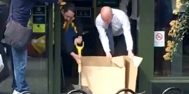 Two employees were filmed using cardboard and a shovel to chase the rat out.