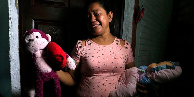 Rosa Ramirez sobs as she shows journalists toys that belonged to her nearly 2-year-old granddaughter Valeria in her home in San Martin, El Salvador, on Tuesday. (AP)