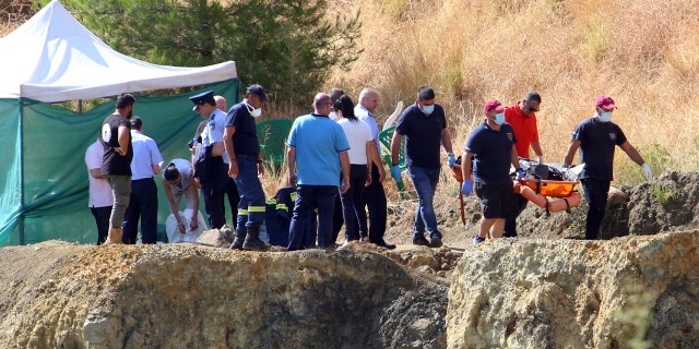 Police officials stand next to a tent where divers brought what is believed to be remains of a 6-year-old girl, near the village of Xiliatos, Cyprus, Wednesday, June 12, 2019.