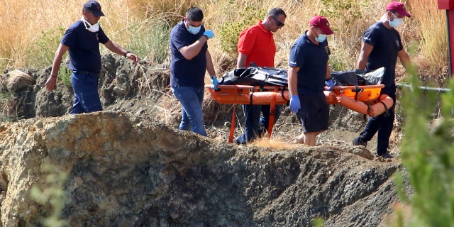 Cyprus police personnel carry a stretcher containing what is believed to be remains of a 6-year-old girl, near the village of Xiliatos, Cyprus, Wednesday, June 12, 2019.