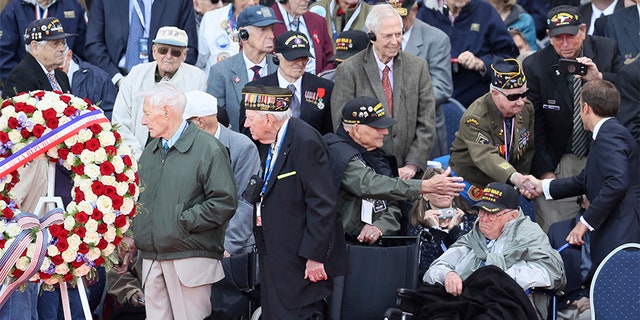 French President Emmanuel Macron, right, greets veterans during a ceremony to mark the 75th anniversary of D-Day at the Normandy American Cemetery in Colleville-sur-Mer, Normandy, France, on Thursday. (AP)