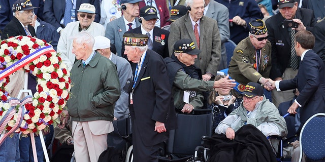 French President Emmanuel Macron, right, greets veterans during a ceremony to mark the 75th anniversary of D-Day at the Normandy American Cemetery in Colleville-sur-Mer, Normandy, France, on Thursday. (AP)
