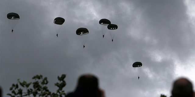 Spectators watch parachutists jumping just as soldiers did 75 years ago for D-Day, Wednesday June 5, 2019 in Carentan, Normandy.