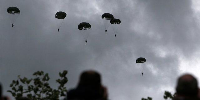 Spectators watch parachutists jumping just as soldiers did 75 years ago for D-Day, Wednesday June 5, 2019 in Carentan, Normandy.