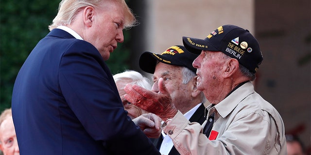 U.S. President Donald Trump talks to a U.S War veteran during a ceremony to mark the 75th anniversary of D-Day at the Normandy American Cemetery in Colleville-sur-Mer, Normandy, France, on Thursday. (AP)