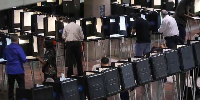 People vote on the first day of early voting in Miami-Dade County, Monday, Oct. 22, 2018, in Miami. (AP Photo/Lynne Sladky)