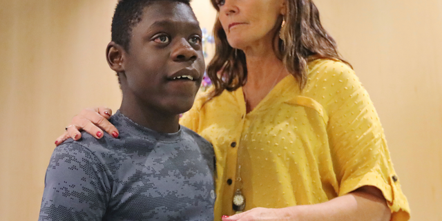 Jerri Hrubes stands next to her son DJ during a news conference Friday, June 7, 2019, in Salt Lake City. Hrubes is calling for an independent investigation after she says a police officer pointed a gun at her 10-year-old son's head in what she calls a racially motivated incident. Hrubes said that a white Woods Cross police officer pulled his gun on her son, DJ, who is black, while he was playing on the front lawn Thursday, June 6, 2019. She says the officer came back to apologize after she called to complain, but that she wants the officer and the agency held accountable. (AP Photo/Rick Bowmer)