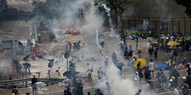 In this file photo taken Wednesday, June 12, 2019, riot police try to disperse protesters with fire tear gas outside the Legislative Council in Hong Kong.