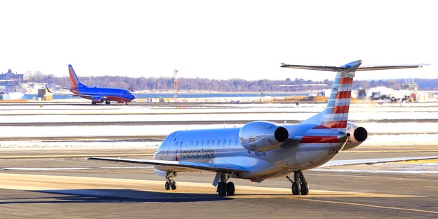 Boston, MA, United States - February 19, 2019: American Airlines Embraer ERJ-140 waiting for take-off from Boston Logan International Airport after snow.