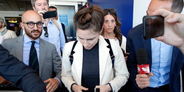 Amanda Knox, center, is approached by journalists upon her arrival in Linate airport, Milan, Italy, Thursday, June 13, 2019. (AP Photo/Antonio Calanni)
