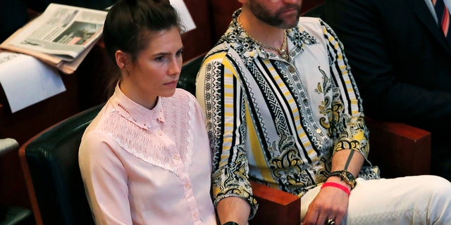 Amanda Knox holds hands with her fiancee Christopher Robinson as they attend a conference during a Criminal Justice Festival at the University of Modena, Italy, Friday, June 14, 2019. Knox, a former American exchange student who became the focus of a sensational murder case, arrived in Italy Thursday for the first time since an appeals court acquitted her in 2011 in the slaying of her British roommate.
