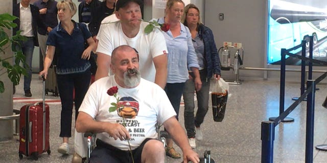 As Mark’s friends exited the aircraft, each one approached the waiting Julie and handed her a single rose.