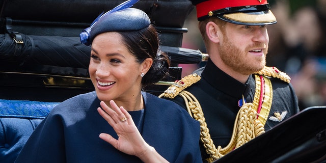 Prince Harry, Duke of Sussex and Meghan, Duchess of Sussex ride by carriage down the Mall during Trooping The Colour