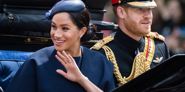 Prince Harry, the Duke of Sussex and Meghan, the Duchess of Sussex in a carriage along the shopping center during Trooping The Color