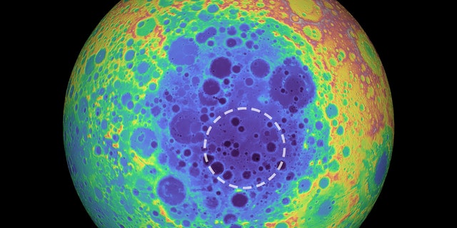 This false-color graphic shows the topography of the far side of the Moon. The warmer colors indicate high topography and the bluer colors indicate low topography. The South Pole-Aitken (SPA) basin is shown by the shades of blue. The dashed circle shows the location of the mass anomaly under the basin. (Credit: NASA/Goddard Space Flight Center/University of Arizona)