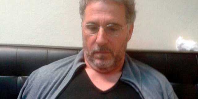 FILE - In this Sept. 3, 2017 file photo released by the Italian police, a man identified by police as longtime fugitive Rocco Morabito, looks down after being arrested at a hotel in Montevideo, Uruguay.